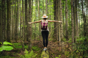 Photo of a woman in the forest standing on a log with her arms outstretched. Your fertility journey can be hard. Discover how to receive support with fertility therapy in San Francisco, CA.