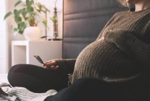 Photo of a pregnant woman sitting on a bed holding an ultrasound photo. Are you feeling overwhlemed with the idea of being a new parent? With therapy for new moms in Marin County, CA you can gain the confidance you need to be a good parent.