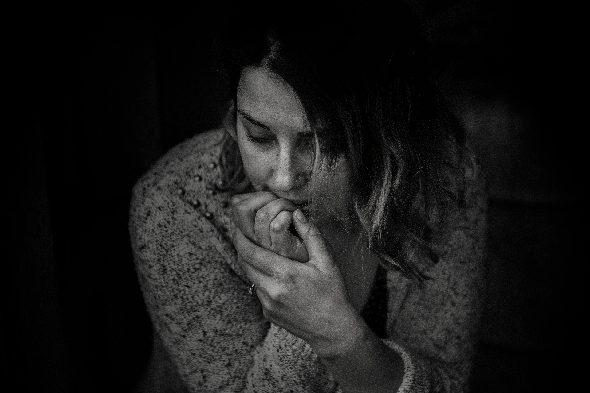 Black and white photo of an anxious woman chewing on her nails. This photo represents how anxiety can cause stress and overwhelm. Discover how anxiety therapy in San Francisco, CA can help you begin managing your symtpoms.