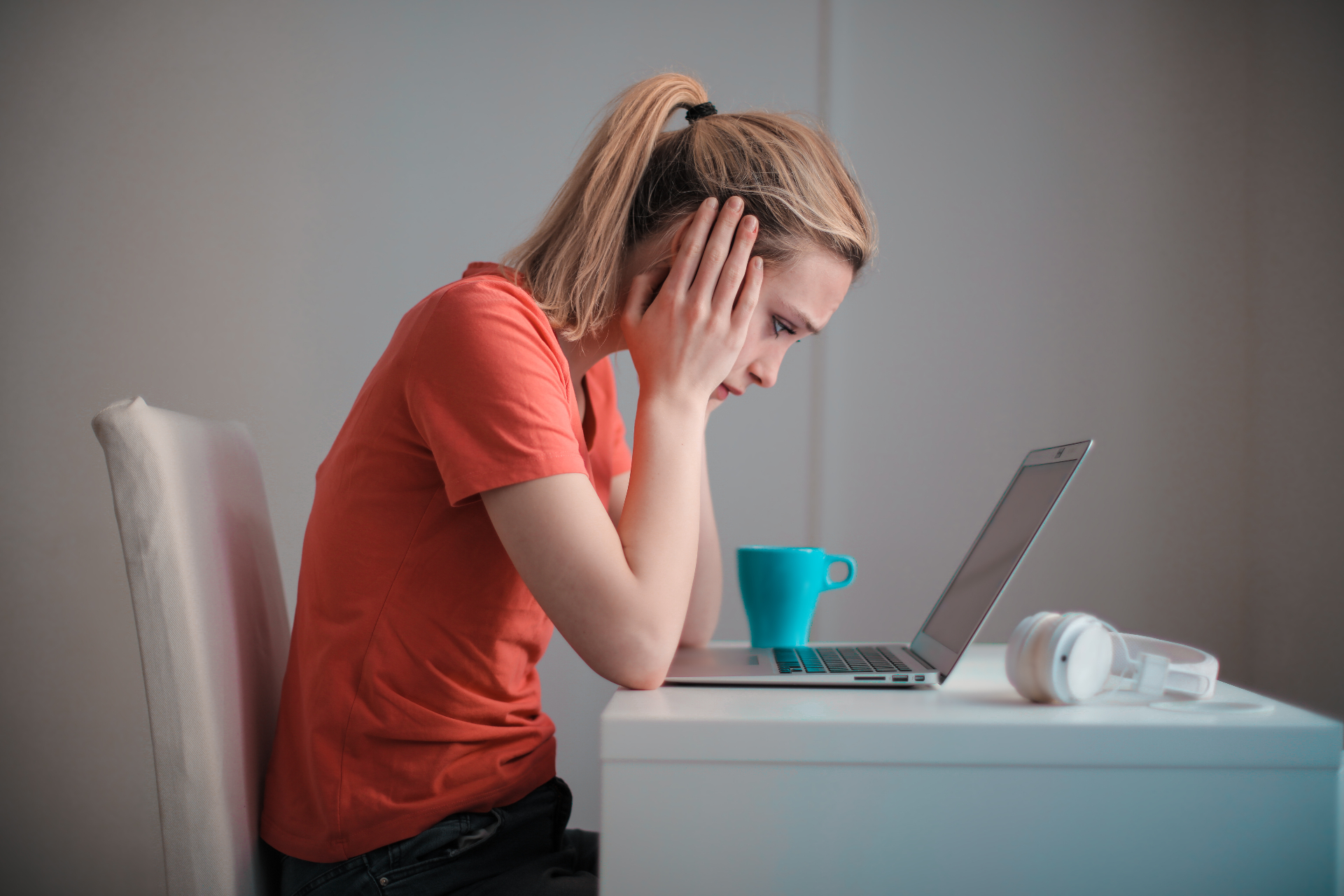 Photo of a woman sitting at her laptop holding her head. This photo represents the stress and overwhelm women feel when it comes to their anxiety. Discover how an anxiety therapist in San Francisco, CA can help you manage your symtpoms.
