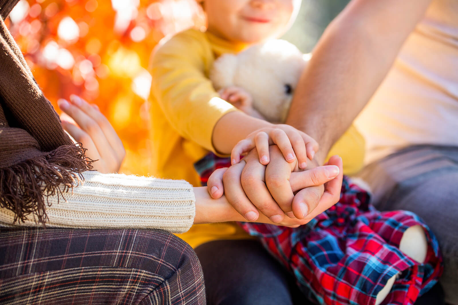 Photo of a mother and father holding hands with their child. Are you struggling with the emotional challenges of motherhood? Learn how counseling for mothers in San Francisco, CA can help you begin to manage.